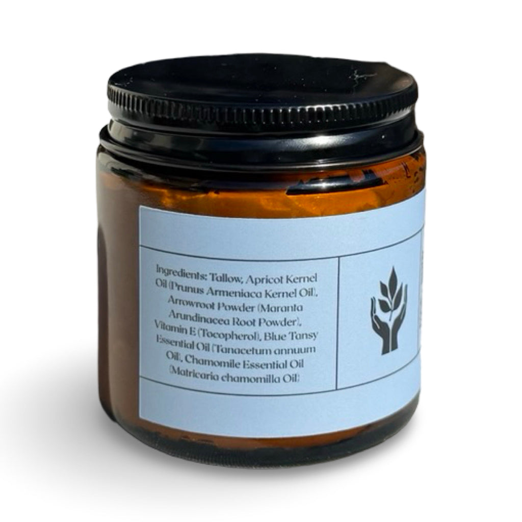 An amber glass jar with a black screw-on lid and a light blue label, photographed on a plain white background.