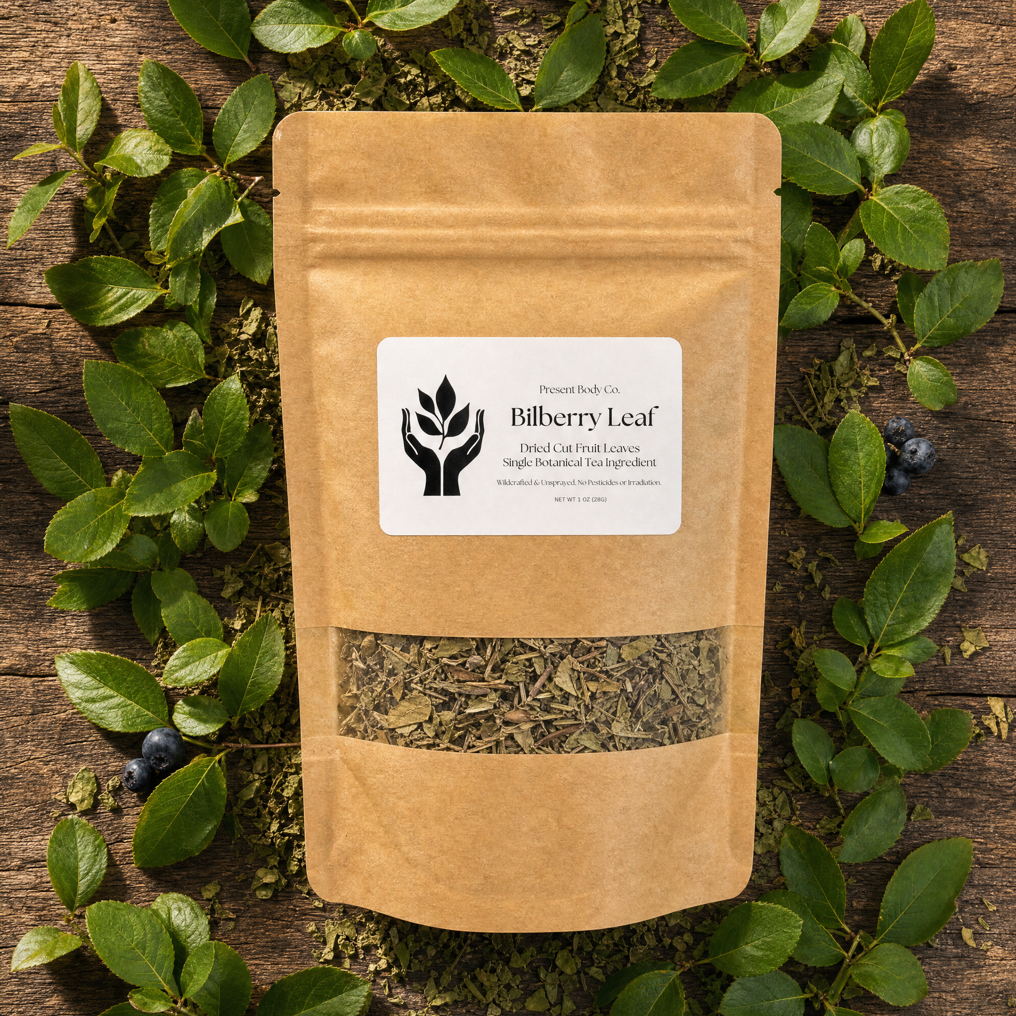 A kraft paper stand-up pouch labeled 'Bilberry Leaf' by Harvest Leaf Co, placed on a rustic wooden surface and surrounded by green bilberry leaves and a few blueberries.