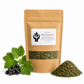 A kraft paper stand-up pouch of Black Currant Leaf by Present Body Co. stands on a white background, with green currant leaves and a small pile of dried green currant leaf beside it.