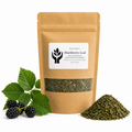 A kraft paper stand-up pouch labeled 'Blackberry Leaf' by Present Body Co., shown on a white background with green leaves and blackberries on the left and a small pile of dried leaf material on the right.