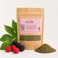 A kraft paper stand-up pouch labeled FLOW by PrunusLeaf Co., shown with green leaves, raspberries, and a small pile of loose dried herbs on a light neutral background.
