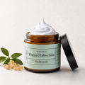 An open amber glass jar of whipped tallow balm with a black lid leaning against it, topped with a swirl of white balm. The label reads 'Present Body Co.
