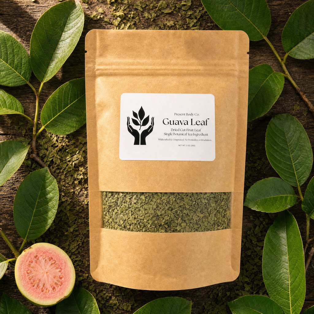 A kraft paper stand-up pouch labeled Guava Leaf, with a clear window showing dried green leaves inside, arranged on a rustic wood surface with fresh green guava leaves and a sliced pink guava fruit around it.