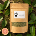 A kraft paper stand-up pouch labeled Guava Leaf, with a clear window showing dried green leaves inside, arranged on a rustic wood surface with fresh green guava leaves and a sliced pink guava fruit around it.