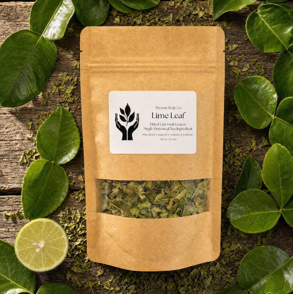 A kraft paper stand-up pouch labeled 'Lime Leaf' with a clear window showing dried green leaves inside, arranged on a rustic wooden surface surrounded by fresh green leaves and a lime slice.