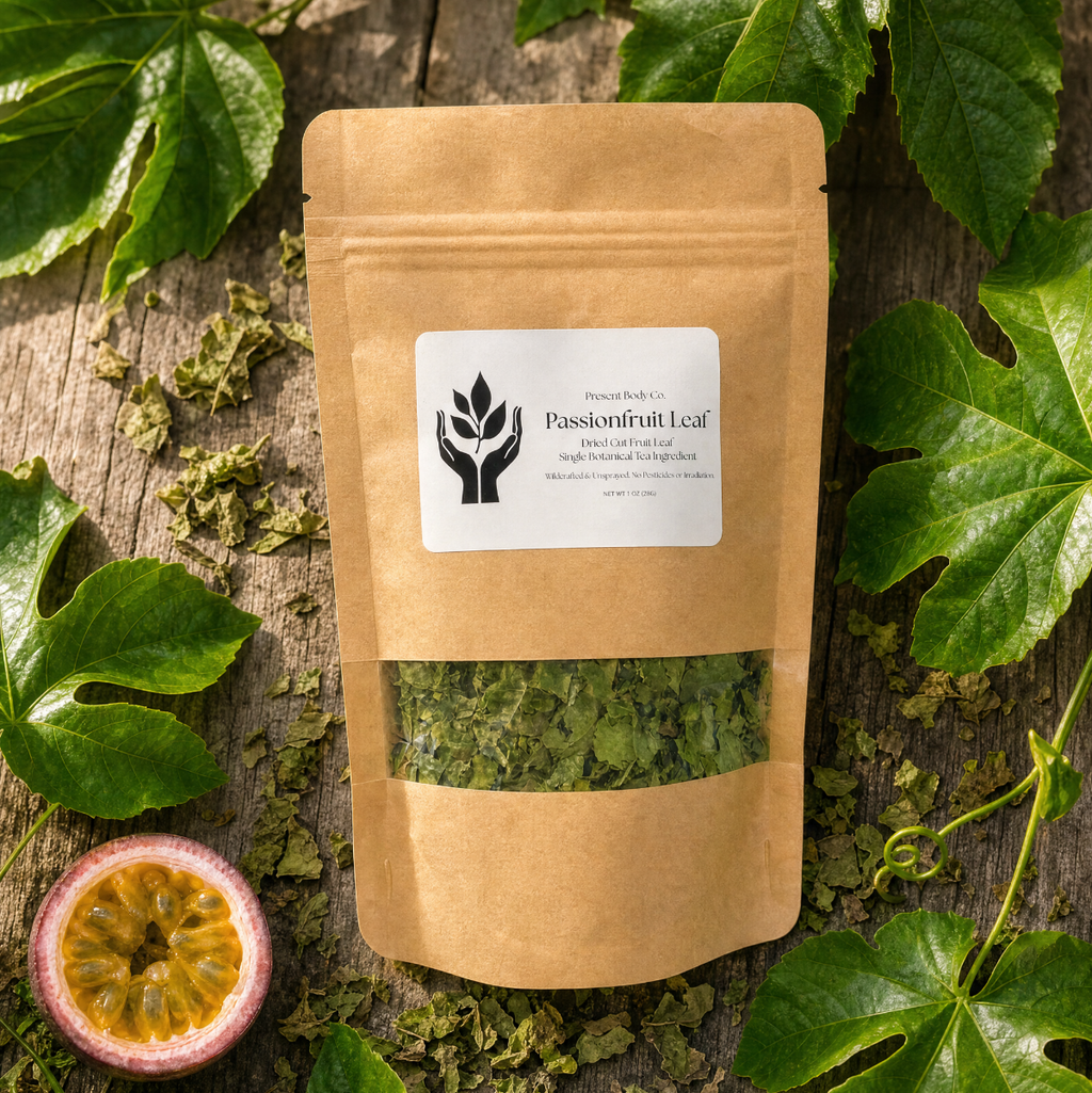 A kraft paper stand-up pouch labeled 'Passionfruit Leaf' with a clear window showing dried green leaves inside, styled on a rustic wood surface with green leaves and a halved passionfruit around it.