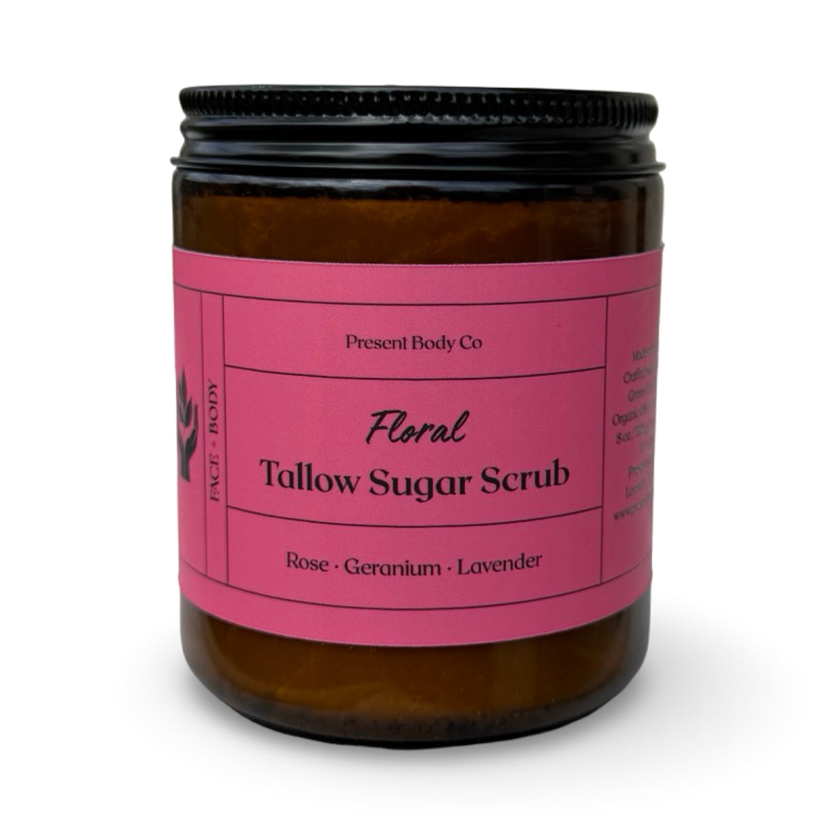 An amber glass jar of Present Body Co. Floral Tallow Sugar Scrub with a bright pink label and a black screw-on lid, set against a plain white background.