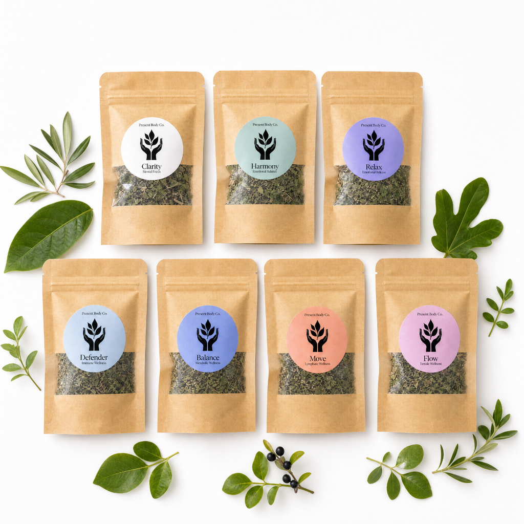 Seven kraft paper stand-up pouches of Present Body Co. tea blends arranged in two rows on a white background, surrounded by green leaves and small botanical sprigs.