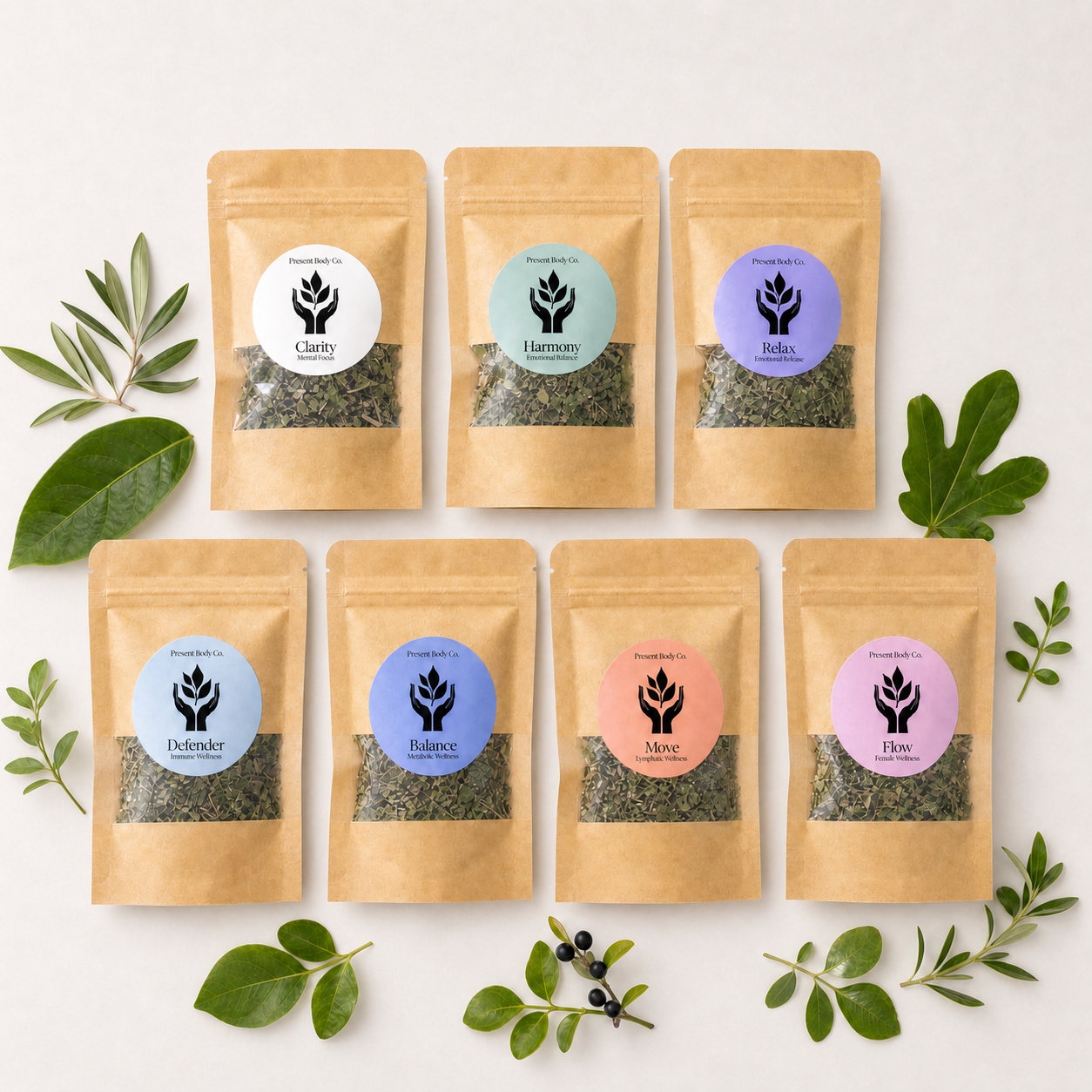 Seven kraft paper pouches of herbal tea arranged in two rows on a white background, surrounded by green leaves and small dark berries. Each pouch has a different colored circular label with a black lotus symbol and text including Clary, Harmonix, Rubia, Epimedium, Mucuna, and Ginseng.