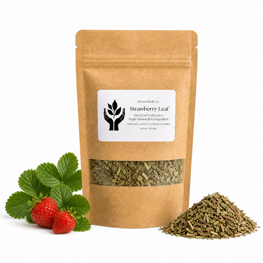 A kraft paper stand-up pouch labeled 'Strawberry Leaf' with a clear window showing dried green leaves inside, styled with fresh green strawberry leaves and two strawberries on the left and a small pile of the dried leaves on the right, on a white background.