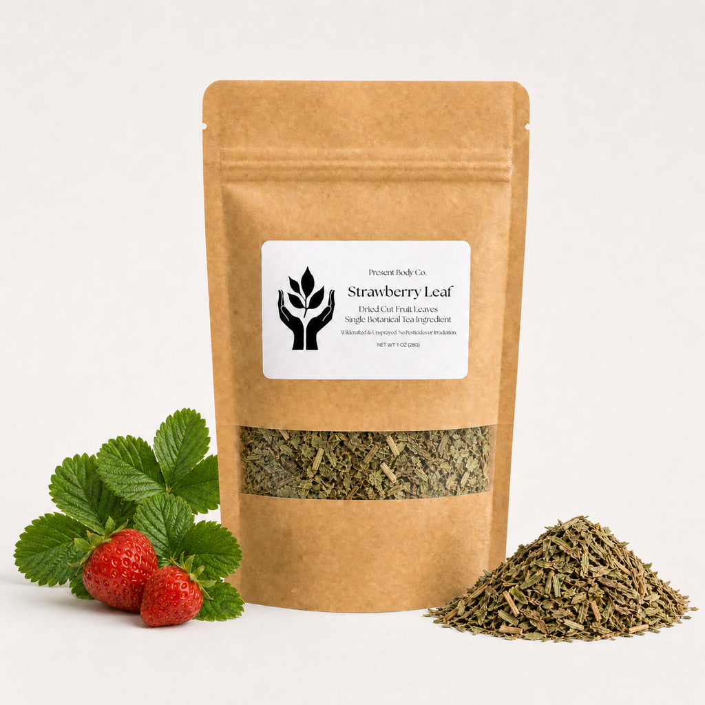 A kraft paper stand-up pouch labeled 'Strawberry Leaf' with a clear window showing dried green leaves inside, styled with fresh strawberry leaves and two strawberries on the left and a small pile of the dried leaves on the right, against a clean white background.